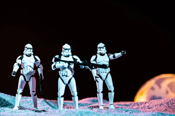 White imperial stormtroopers with weapon on cosmic planet isolated on black — стокове фото