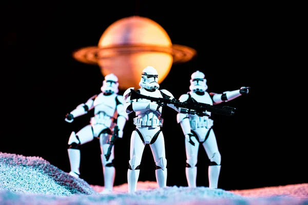 White imperial stormtroopers with guns on cosmic planet isolated on black — Fotografia de Stock