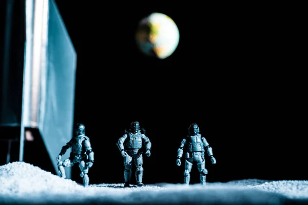 Toy soldiers standing in space on black background with planet earth — Stock Photo