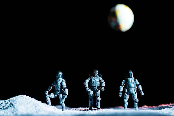 Toy soldiers standing on planet in space on black background with planet earth — Stock Photo