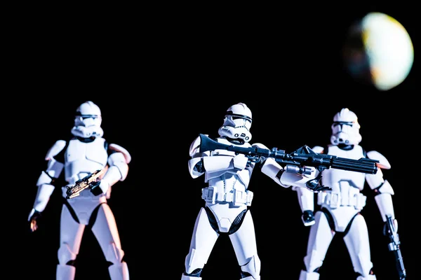 Armed white imperial stormtroopers on black background with planet Earth — Stock Photo