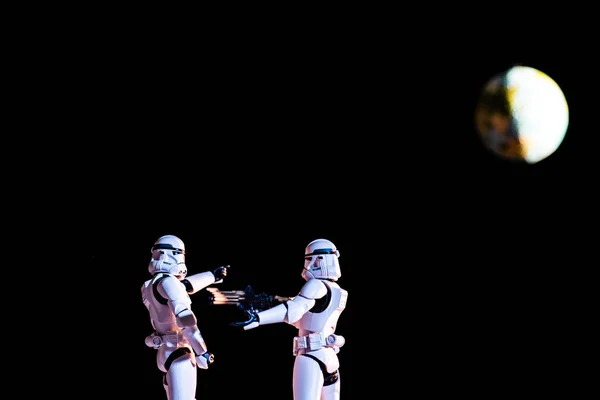 White imperial stormtroopers on black background with planet Earth — Stock Photo