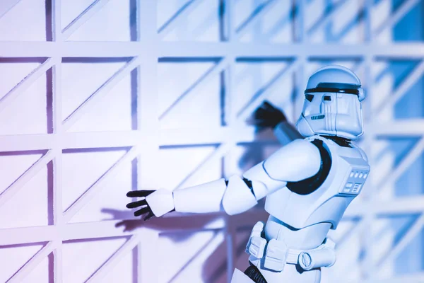 Plastic Imperial Stormtrooper climbing white textured wall — стокове фото