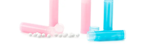 Panoramic shot of pink and blue bottles near round pills on white — Stock Photo