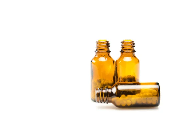 Foyer sélectif de petites bouteilles avec des pilules rondes isolées sur blanc — Photo de stock
