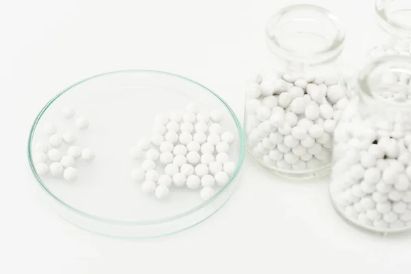 Selektiver Fokus von Flaschen mit Medikamenten in der Nähe von Petrischalen isoliert auf Weiß — Stockfoto