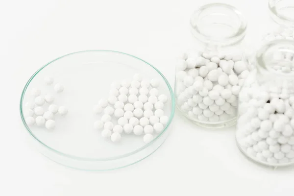 Selective focus of bottles with medicine near petri dish isolated on white — Stock Photo