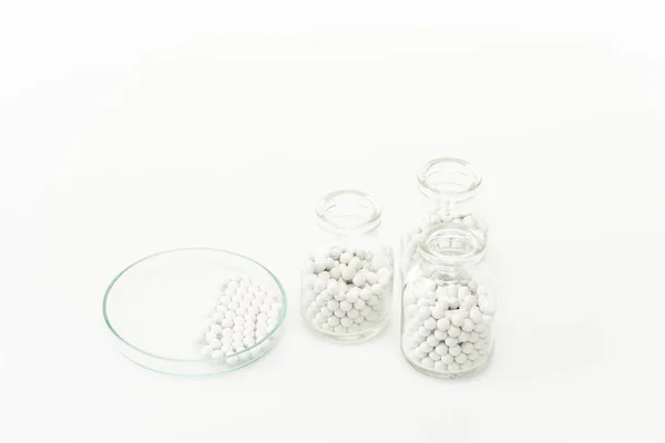 Frascos con pastillas cerca de placa de vidrio aislado en blanco - foto de stock