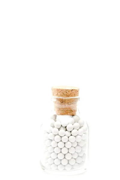 Round pills in glass bottle with wooden cork isolated on white — Stock Photo