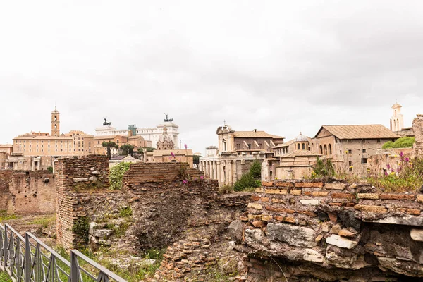Buildings and ruined bricked walls under grey sky in rome, italy — Stock Photo