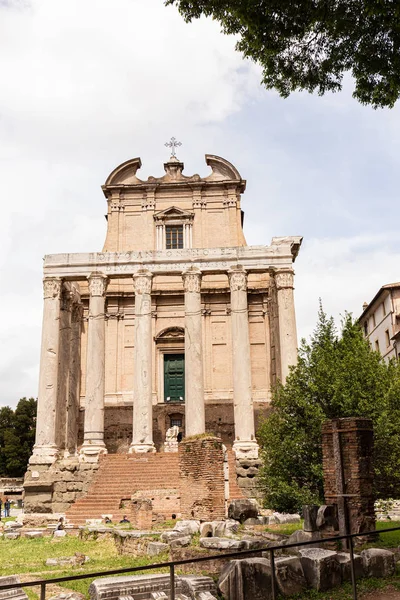 ROMA, ITALIA - 28 DE JUNIO DE 2019: antiguo templo de Antonino y Faustina bajo el cielo azul - foto de stock