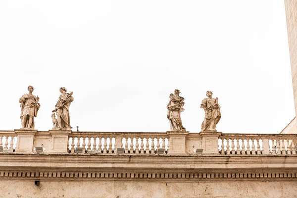 ROMA, ITALIA - 28 DE JUNIO DE 2019: Edificio antiguo con estatuas romanas bajo cielo gris - foto de stock