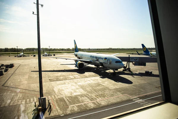 ROMA, ITALIA - 28 GIUGNO 2019: aeroplani in aeroporto sotto il cielo nella giornata di sole dietro la finestra — Foto stock