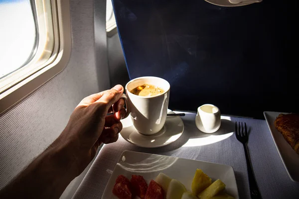 Partial view of man with cup of coffee and food in airplane, rome, italy — Stock Photo