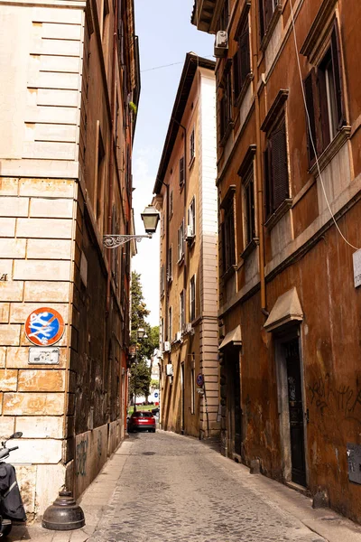 Rom, italien - 28. juni 2019: enge straße und rotes auto bei sonnigem tag in rom, italien — Stockfoto