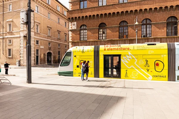 ROMA, ITALIA - 28 DE JUNIO DE 2019: pareja parada cerca del autobús amarillo en la calle en un día soleado - foto de stock