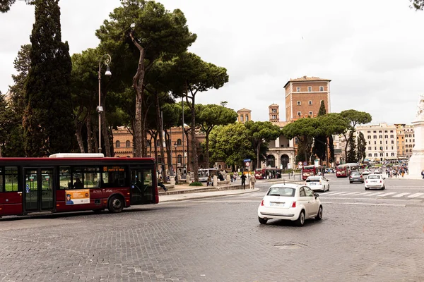 ROME, ITALIE - 28 JUIN 2019 : personnes, bus et voitures dans la rue près des vieux bâtiments et des arbres verts — Photo de stock