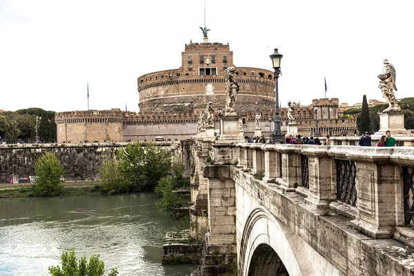 Rom, Italien - 28. Juni 2019: Tiber und Menschen auf alter Brücke unter wolkenverhangenem Himmel — Stockfoto
