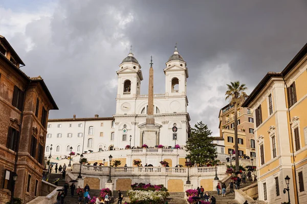 ROMA, ITALIA - 28 GIUGNO 2019: folla di turisti con ombrelloni che camminano vicino agli edifici pld sotto il cielo coperto — Foto stock