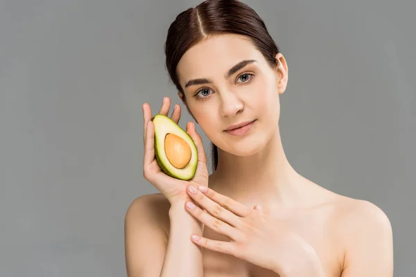Beautiful naked woman holding avocado half isolated on grey — Stock Photo