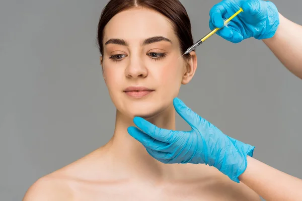 Visão recortada de cirurgião plástico que faz injeção de beleza para mulher isolada em cinza — Fotografia de Stock