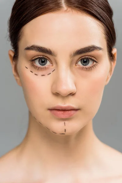 Jovem mulher grave com marcas no rosto isolado no cinza — Fotografia de Stock