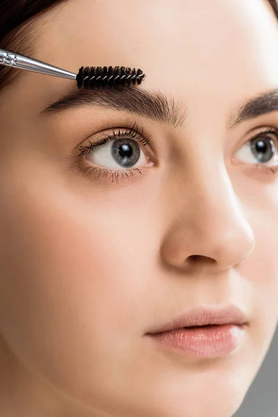 Belle jeune femme coiffant sourcil avec brosse à sourcils — Photo de stock