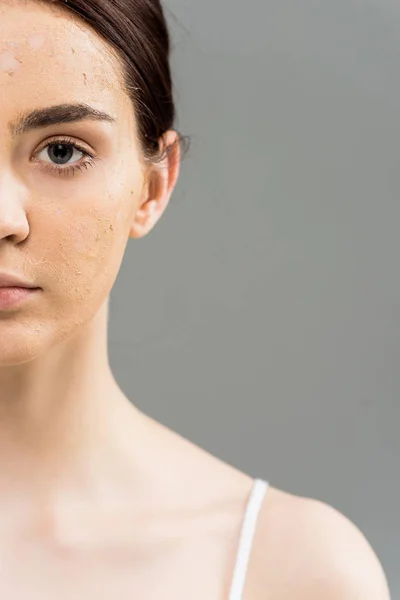 Vue recadrée de la jeune femme brune avec gommage du visage sur la peau — Photo de stock