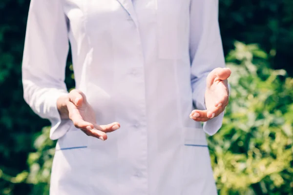 Cropped view of doctor in white coat in park — Stock Photo