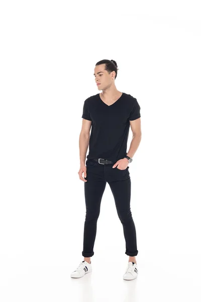 Vue pleine longueur de brune jeune homme en vêtements noirs avec la main dans la poche isolé sur blanc — Photo de stock