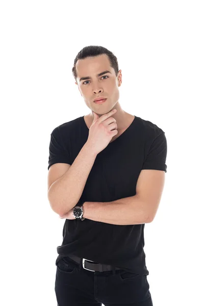 Vista frontal del joven pensativo en camiseta negra mirando a la cámara aislada en blanco - foto de stock