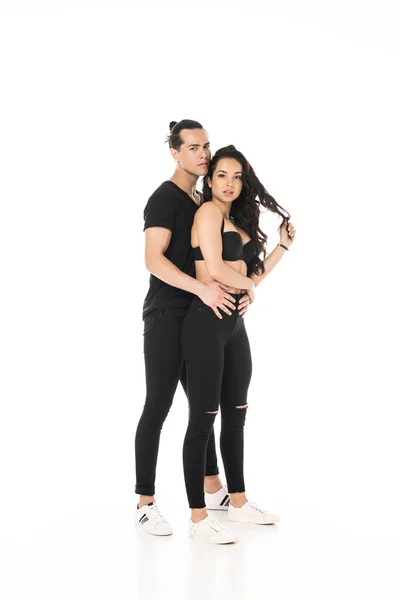 Vue pleine longueur du couple en vêtements noirs embrassant isolé sur blanc — Photo de stock