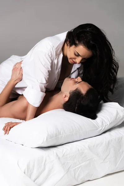 Sexy young couple embracing while lying on bed — Stock Photo