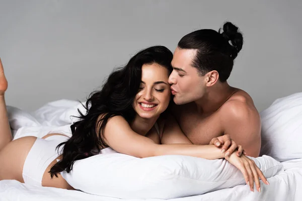Сексуальна роздягнена пара посміхається, лежачи на ліжку разом — стокове фото