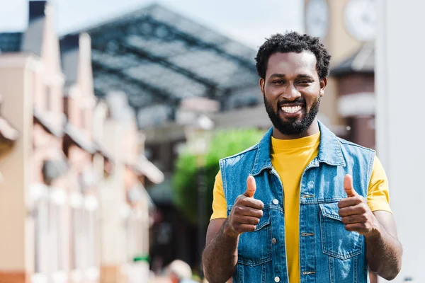 Homme afro-américain joyeux montrant pouces vers le haut tout en regardant la caméra — Photo de stock