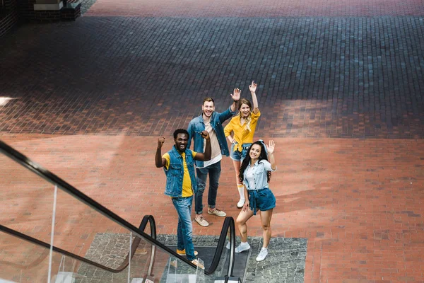 Feliz grupo multicultural de amigos haciendo gestos mientras están de pie juntos — Stock Photo