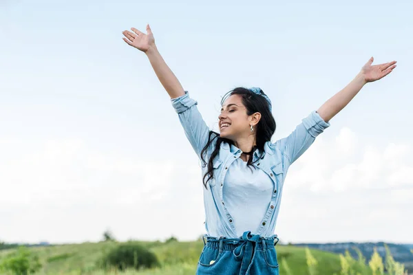 Cheerful young woman with  closed eyes and outstretched hands — Stock Photo