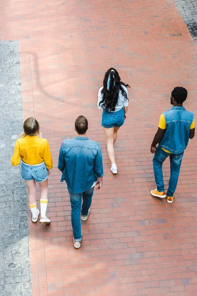 Vista trasera de amigos multiculturales caminando juntos - foto de stock