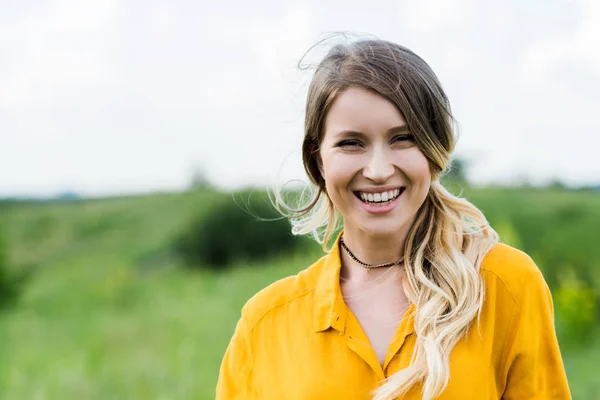 Positive jeune femme souriant tout en regardant la caméra — Photo de stock