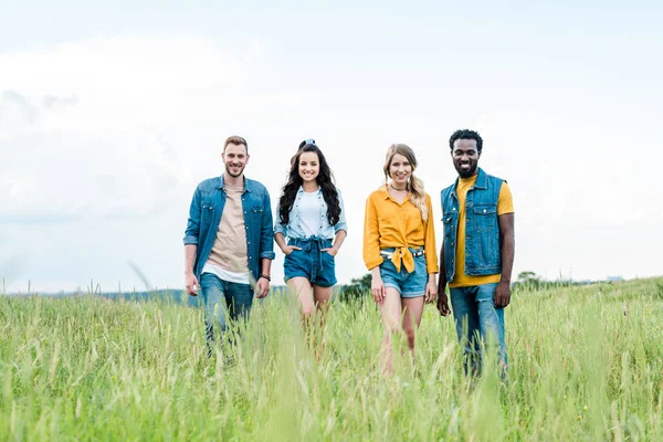 Selektiver Fokus glücklicher multikultureller Freunde, die zusammenstehen und in die Kamera schauen — Stockfoto