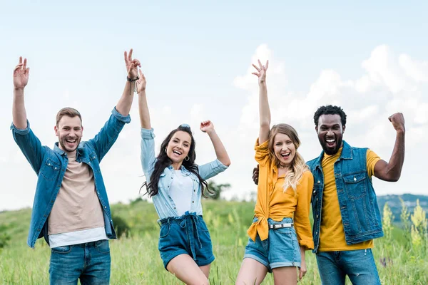 Felici amici multiculturali in piedi insieme e gesticolando mentre celebrano il trionfo — Foto stock