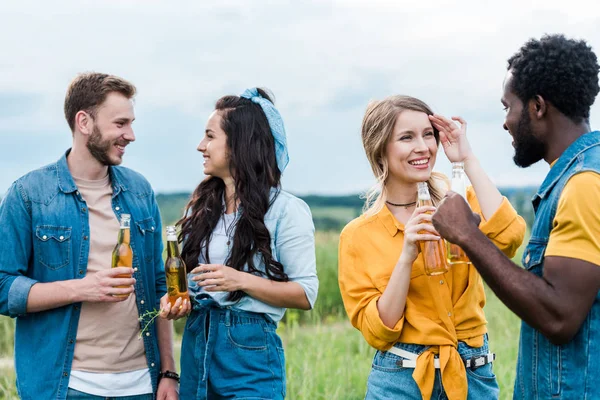 Fröhliche multikulturelle Männer und Frauen mit Flaschen und Bier — Stockfoto