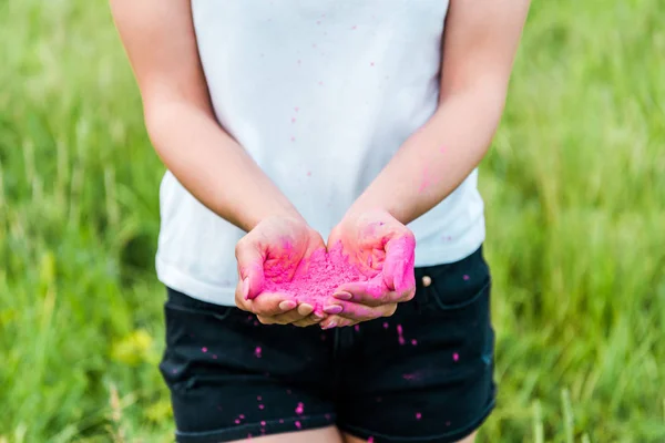 Обрізаний вид молодої жінки, що тримає рожевий порошок в руках — стокове фото