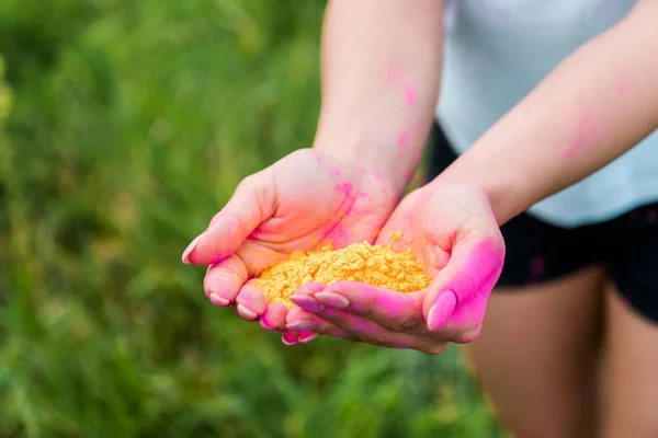 Ausgeschnittene Ansicht einer jungen Frau mit gelber Holi-Farbe in den Händen — Stockfoto