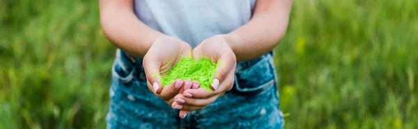 Panoramaaufnahme einer jungen Frau mit grüner Holi-Farbe in den Händen — Stockfoto