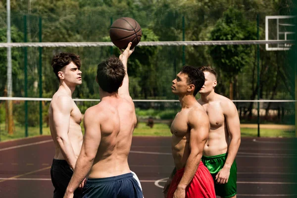 Cuatro jugadores de baloncesto sexy sin camisa de entrenamiento en la cancha de baloncesto - foto de stock