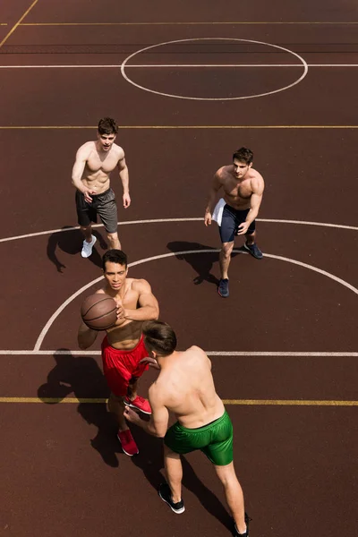 Vista aérea de cuatro jugadores de baloncesto sin camisa con pelota en la cancha de baloncesto - foto de stock