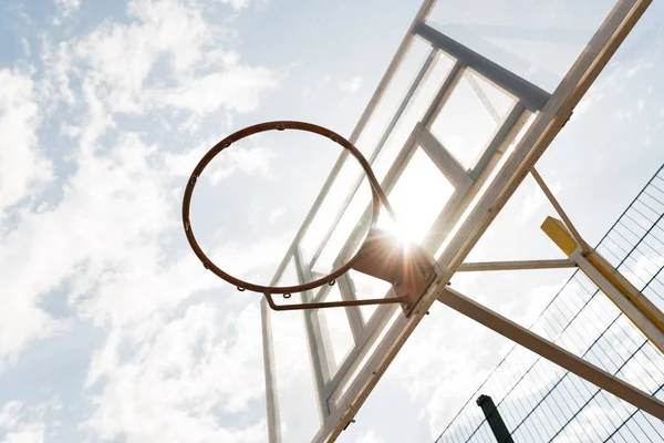 Vue du bas de la planche de basket sous le ciel bleu avec des nuages par temps ensoleillé — Photo de stock