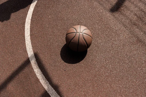 Ball on brown playing surface at basketball court — Stock Photo