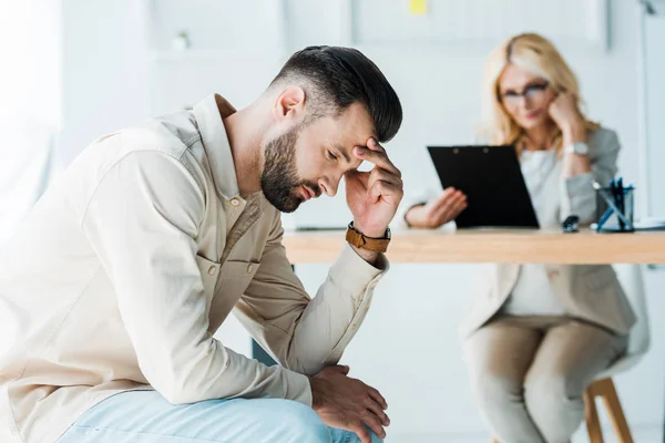 Selektiver Fokus eines frustrierten Mannes, der in der Nähe eines blonden Personalvermittlers sitzt — Stockfoto